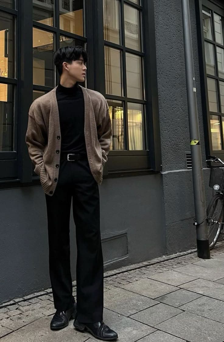 Camel cardigan over a black turtleneck with black wide-leg trousers